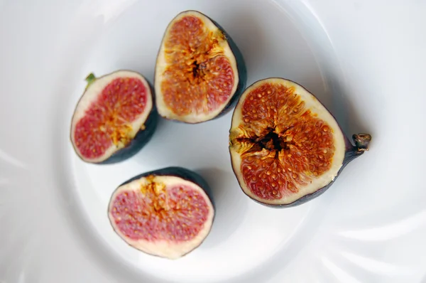 Фон из свежих фруктов с спелыми инжирами на белой тарелке — стоковое фото
