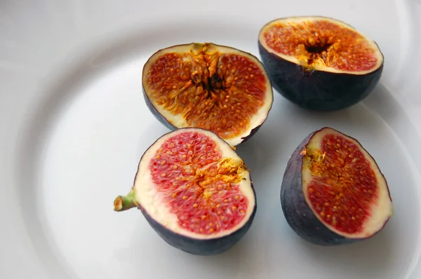 Фон из свежих фруктов с спелыми инжирами на белой тарелке — стоковое фото