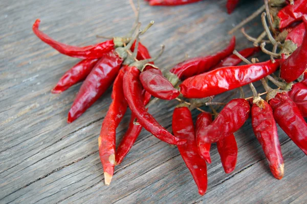 Pimientos rojos picantes sobre mesa de madera — Foto de Stock