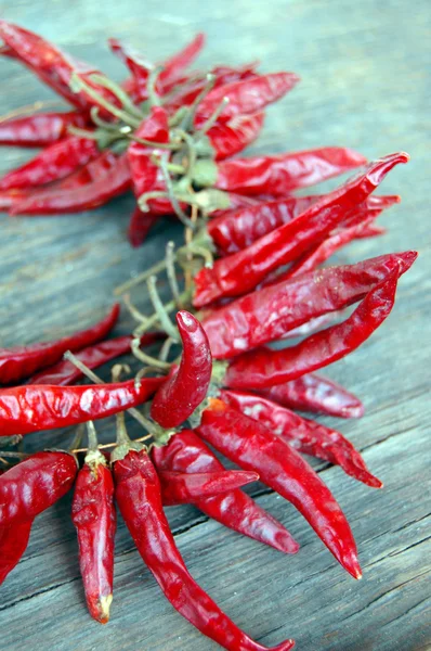 Pimientos rojos picantes sobre mesa de madera — Foto de Stock