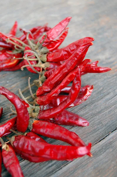 Pimientos rojos picantes sobre mesa de madera — Foto de Stock