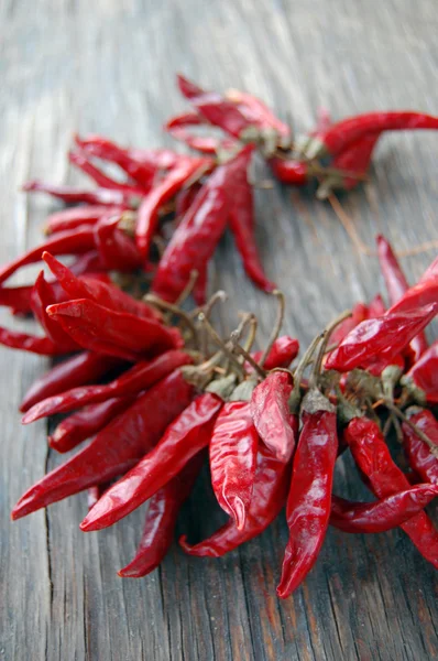 Pimientos rojos picantes sobre mesa de madera — Foto de Stock