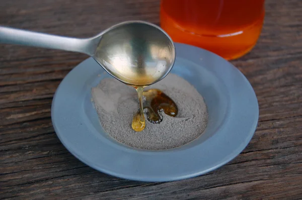 Косметическая глина в керамической миске с медом . — стоковое фото
