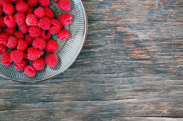 Raspberries on rustic wooden table — Stock Photo, Image