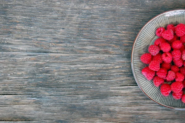 Raspberries on rustic wooden table — Stock Photo, Image