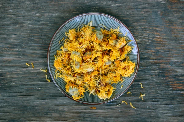 Dried marigold on wooden table — Stock fotografie