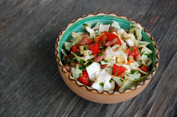 Fresh tomato and cabbage salad with parsley in ceramic bowl on rustic wooden table — Stock Photo, Image