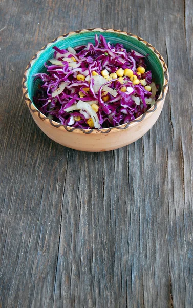 Φρέσκο κόκκινο λάχανο σαλάτα με καλαμπόκι σε κεραμικά μπολ σε ρουστίκ ξύλινα πίνακα — Φωτογραφία Αρχείου