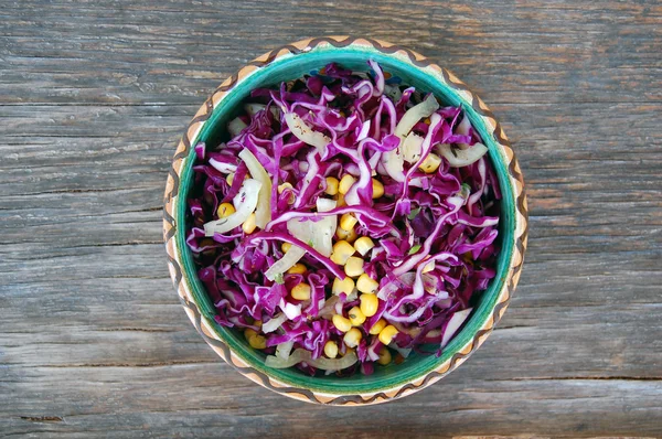 Salada de repolho vermelho fresco com milho doce em tigela de cerâmica na mesa de madeira rústica — Fotografia de Stock