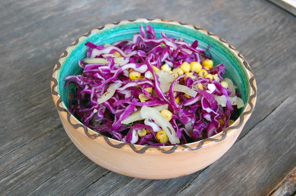 Salade de chou rouge frais avec maïs sucré dans un bol en céramique sur une table en bois rustique — Photo
