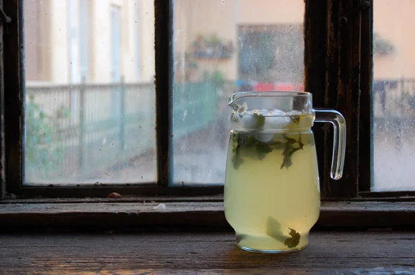 Limun segar yang dibuat dengan mint, dengan latar belakang jendela kayu lama — Stok Foto