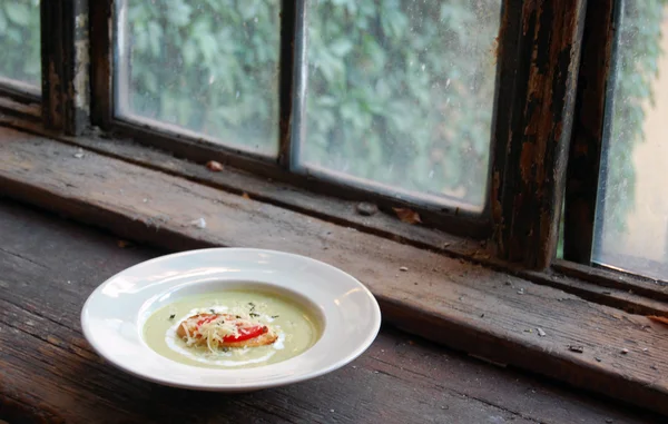 Primer plano de sopa de guisantes verdes con pan y queso en la parte superior — Foto de Stock