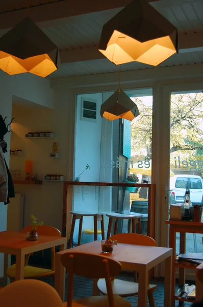 Интерьер кафе с дизайнерскими лампами и оранжевыми стульями — стоковое фото