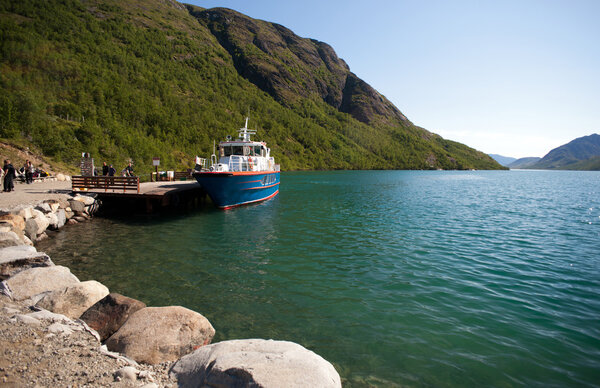 MEMURUBU, NORWAY - JULY 22, 2013: Hikers leaving boat at Memurub