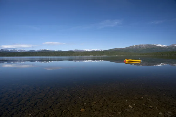 Yellow boat on tranquil lake with snow covered mountains, Norway — Stock Photo, Image