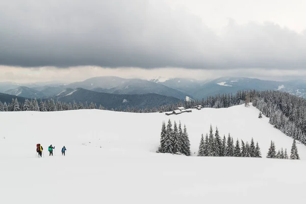 Hikers approaching a shelter deep in the winter mountains