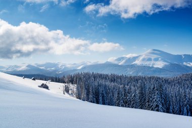 Dağlık dağlarda kulübeleri olan kış manzarası