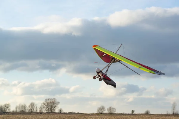 勇敢的女孩在彩色的悬挂滑翔翼上学习飞翔 以美丽的日落天空为背景的极限运动 掌握滑翔机 — 图库照片