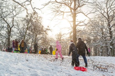 Kyiv, Ukrayna, 15 Ocak 2021, kızaklı çocuklar güneşli bir günde kış parkında eğleniyorlar.