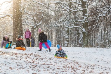 Kyiv, Ukrayna, 15 Ocak 2021 çocuklar güneşli bir günde kış parkında kızak kayarken eğleniyorlar. 