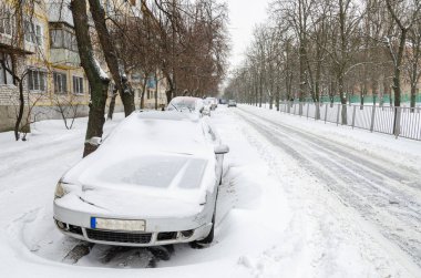 Yakınlarda kaygan bir yol olan derin bir gösteride park edilmiş bir araba. Araba kullanmak için kötü hava.