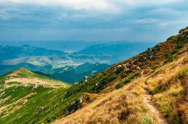 Dağların tepesindeki patika. Dağlık arazide yürüyüş yolu. İnanılmaz dağ manzarası..