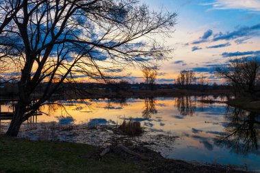 Gölde sihirli günbatımı. Kırsal kesimde sakin bir akşam. Balıkçılık, meditasyon ve sosyal mesafeler için mükemmel bir yer..