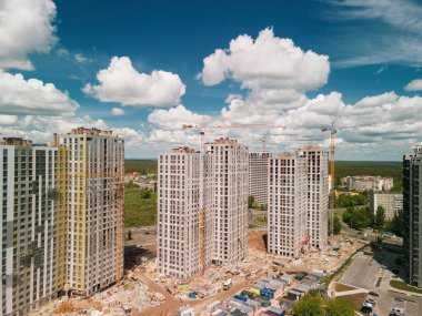 Aerial view on construction site of high rise buildings with cranes, machinery and scaffoldings. Development investment advertising