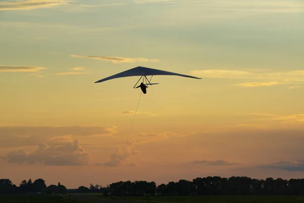 パラグライダー翼のシルエット 夕暮れ時の空飛ぶ翼 — ストック写真