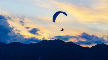 2021-08-17 Meduni, İtalya. Arkaplanda günbatımı bulutları olan paraglider kanadı