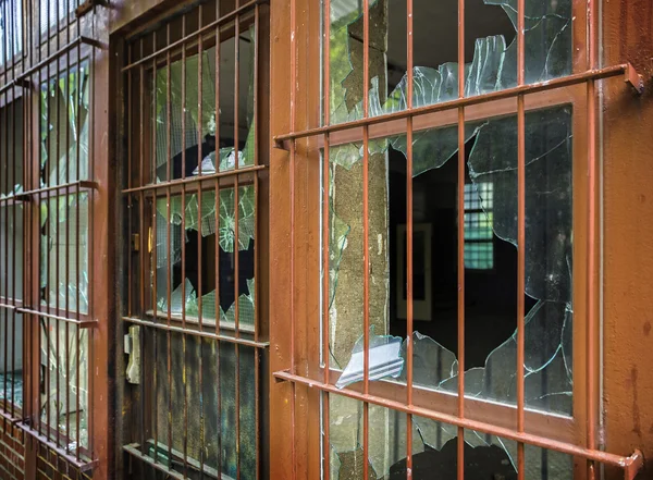 Çubuklu bir kapı kırık pencere camı — Stok fotoğraf