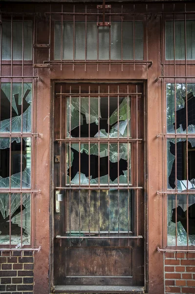Vidros quebrados em uma porta barrada — Fotografia de Stock