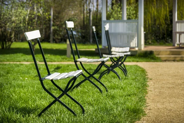 Fehér összecsukható székek, a kertben — Stock Fotó