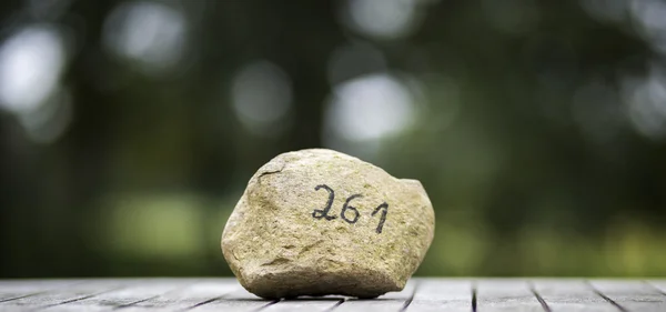 A stone with numbers on the table — Stock Photo, Image