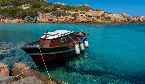 Ships and boats in the turquoise blue sea off the coast of Sardinia, Italy