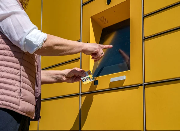 一个女人在德国Dhl典型的黄色德国包装站收发邮件 — 图库照片
