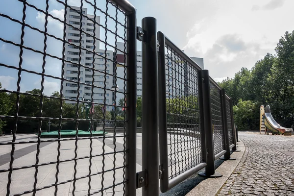 Kijkend naar de ketting-link hek op een high-rise landgoed — Stockfoto