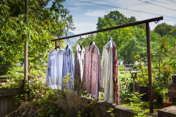 Dress shirts hanging on a clothes rod in the garden — Stock Photo, Image