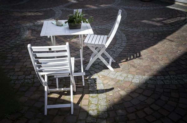 Beyaz Bahçe sandalye ve bir alışveriş caddesi tabloda — Stok fotoğraf