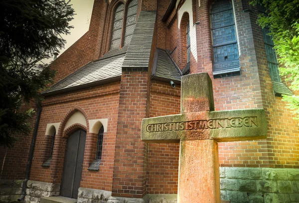 Cruz de piedra frente a la iglesia —  Fotos de Stock