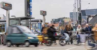 Hollanda 'daki Amsterdam Merkez İstasyonu' nda hız etkisi, bisikletçiler ve banliyö sakinleri ile hareket bulanıklığı