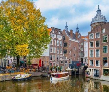 Tarihsel mimari ve Amsterdam 'ın eski şehir Amsterdam, Hollanda' da botları ve kanalları olan tipik şehir manzarası