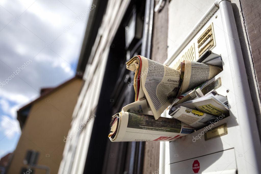 a mailbox with advertising and newspapers