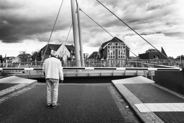 Een senior wachten bij de gate van een draaibrug — Stockfoto