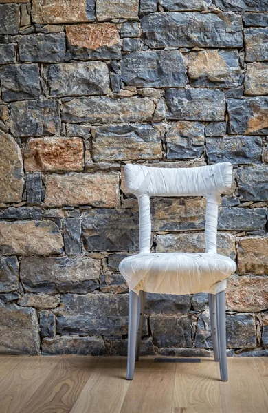 Speciální židle stojí před kamenná zeď — Stock fotografie