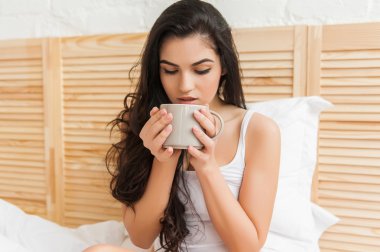 sevimli genç güzel kadın yatakta kahve içme