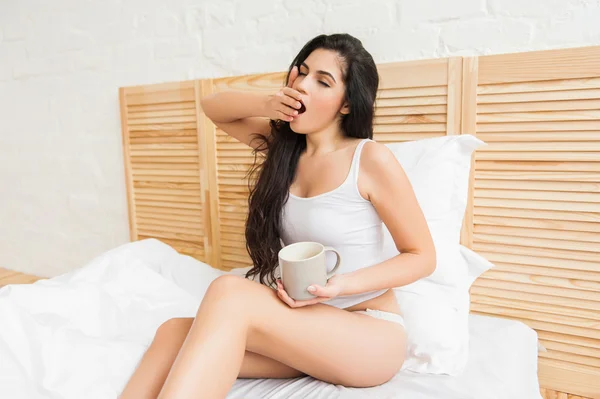 Linda joven hermosa mujer beber té y bostezar — Foto de Stock