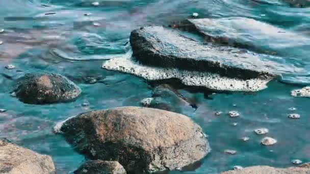 Бризки води на кам'янисті пляжі берега озера — стокове відео