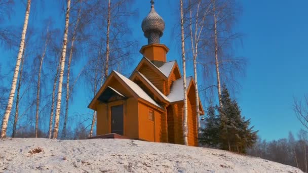 Piccola chiesa di legno in un giorno d'inverno soleggiato e nevoso — Video Stock