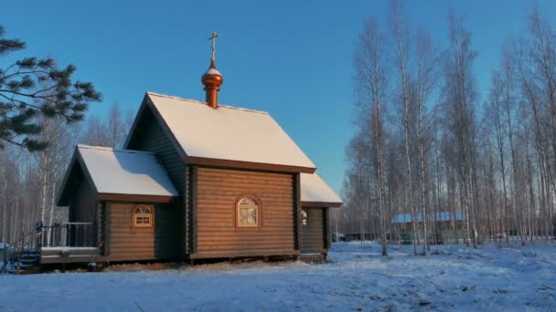 Kleine Holzkirche an einem sonnigen, verschneiten Wintertag — Stockvideo